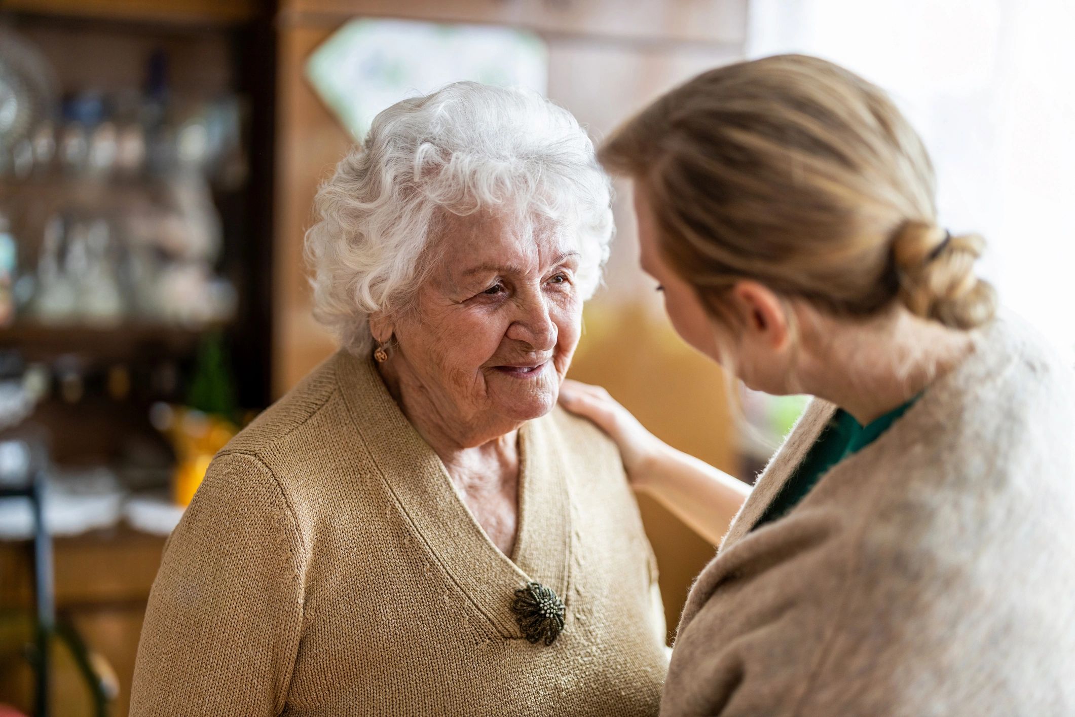 Companion speaking warmly with a senior client during a home visit